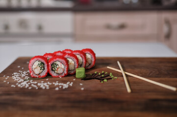 sushi roll with salmon, cucumber and wasabi on wooden board