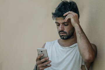 Fototapeta premium grunge man with mobile phone on street wall