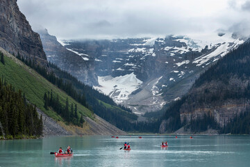 Tourists ipaddle in red kayaks on Lake Louise