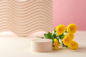 Round podium for the presentation of products and cosmetics. Empty stand for packaging. Cosmetic beauty showcase with yellow chrysanthemum flowers.