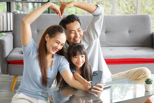 Happy Asian family making heart symbol in living room while video call.  Family,love and happiness concept.
