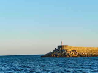Breakwater in the sea at sunset