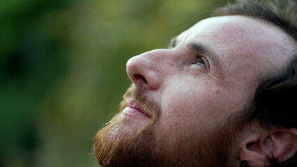 Fototapeta premium Grateful man closing eyes in meditation. Person opening eye to sky with HOPE and FAITH. Spiritual person smiling in contemplation