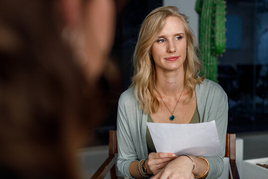 Smiling businesswoman listening to colleague in office