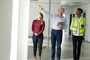 Fototapeta premium Professional senior engineer builder showing clients around in the new development building