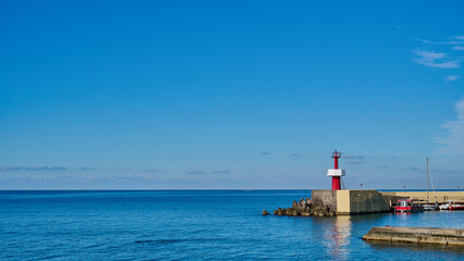 Panoramic view of little red lighthouse on the pier against the blue sky on sunny day, copy space
