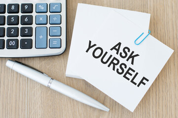 ASK YOURSELF text on a card on a wooden background, business concept
