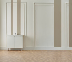 Bath room, white and brown wall, cabinet sink and laundry clothes, vase of plant, lamp.