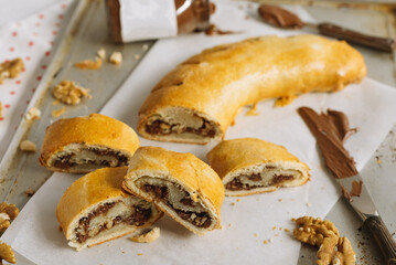 Roll with chocolate paste filling and walnuts. Homemade sweet pastries.