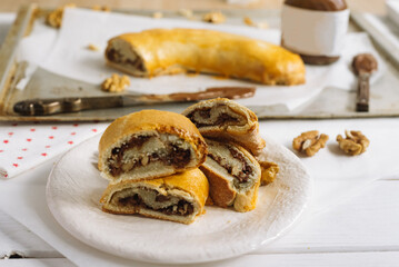 Roll with chocolate paste filling and walnuts. Homemade sweet pastries.