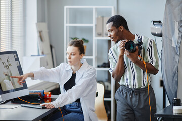 Portrait of two photographers working as team on product photoshoot in studio