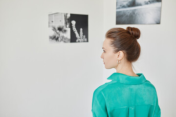 Minimal portrait of young woman visiting photo gallery and enjoying art, copy space