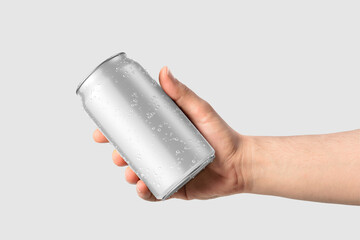 Aluminium drink can 330ml with water drops in a hand mockup template, isolated on light grey background. High resolution. - obrazy, fototapety, plakaty