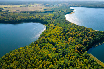 Widok z drona na jezioro Wierzchowo w Polsce. Zielony las otaczający jezioro i czysta niebieska...