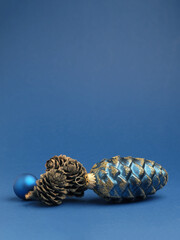 Blue Christmas bauble with pine cones on blue