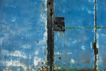 Old blue gate. Details of industrial area. Truck transport. Blue steel wall.