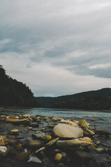 mountain river between sheer cliffs . blue clear water of the river. Young green leaves of trees