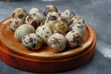 quail eggs in wooden bowl on dark background 