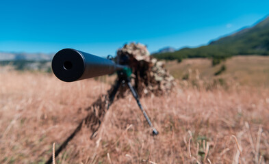 army soldier holding sniper rifle with scope and aiming in forest. war, army, technology and people...