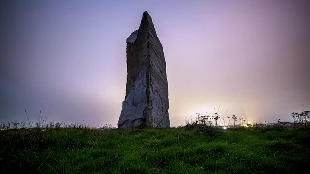 Nighttime Dolly shot of Millenium Rock in L'Ancresse Common with Citylights in Background, Hyperlapse Guernsey