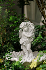 Fototapeta na wymiar Cute baby corner antique stone doll statue, close-up of newly built home garden stone statue.