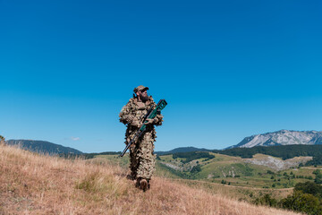 army soldier holding a sniper rifle with scope and walking in the forest. war, army, technology and...