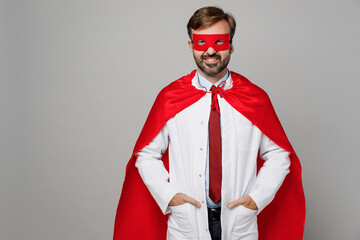 Male doctor man wears white medical gown suit work in hospital wear red super hero coat stand...