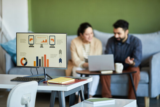 Workplace Of Economist Or Analyst With Graphic Data On Screen Of Computer Standing Against Two Colleagues Networking