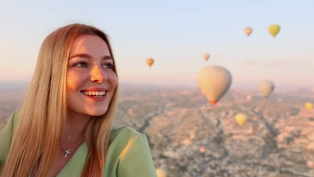 close-up of a happy smiling woman flying on a hot air balloon admiring the landscape. Cappadocia Balloon Festival.