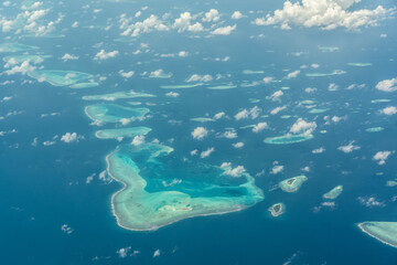 Aerial view of the Maldives islands and atolls. Maldives tourism and travel background. Beautiful blue sea, coral reef and atoll nature landscape, season, exotic destination