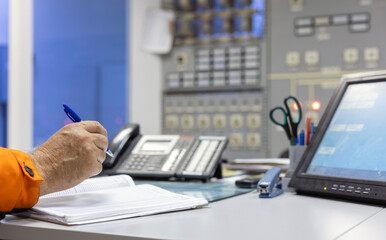 The hand of a dispatcher with a handle working in an electrical panel at an electrical substation....