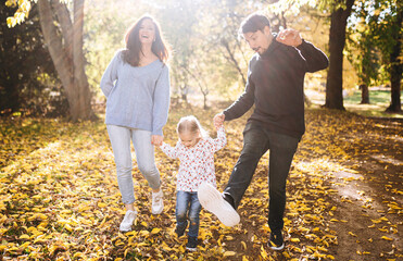 Fototapeta premium happy family with little daughter in autumn park outdoor recreation.