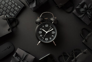 Black friday concept. Top view photo of black alarm clock gift boxes with ribbon bows paper bags...