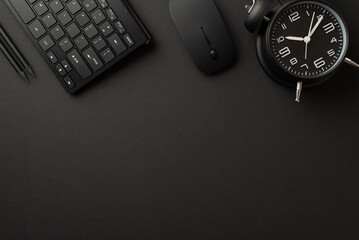 Black friday concept. Top view photo of black alarm clock pencils computer mouse and keyboard on...