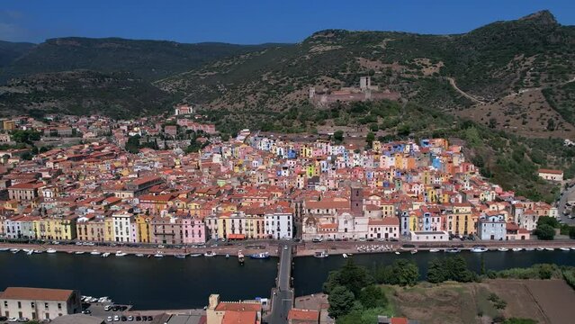 Aerial of ancient town and commune of Bosa city in Sardinia, Italy on banks of Temo river. Birds eye view.