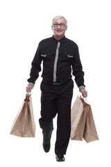 casual man with shopping bags striding forward.