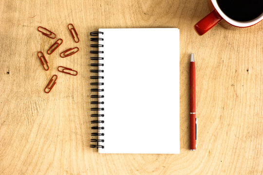 notebook and pen on wooden background