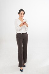 Studio portrait photo of a young beautiful elegant Brazilian female businesswoman lady wearing smart casual business attire posing with a series moments of emotion and gesture of using her smartphone