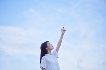 夕暮れ時の青空と白いワンピースを着た女性