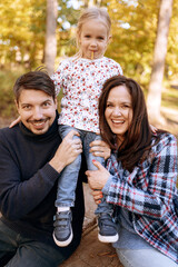 happy family with little daughter in autumn park outdoor recreation.