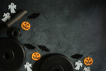 Dumbbell barbell weight plates and Halloween decorations - pumpkins, bats and ghosts. Healthy...