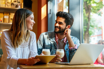 Happy couple in love using digital devises for work, study or social media.