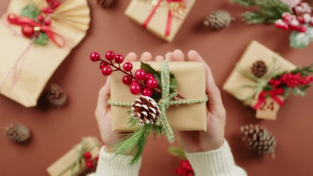 Holding Christmas Package. Brown Background 