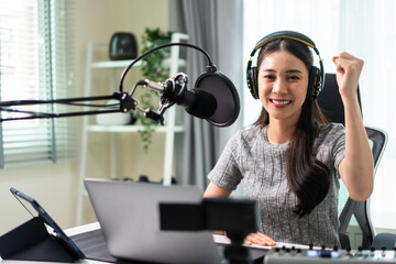 Asian attractive audio DJ woman speaks into microphone to broadcasting. 