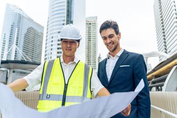 Caucasian businessman and Asian worker working in outdoors in city. 