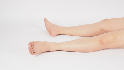 Asian Male legs and barefoot lie down on the white background.