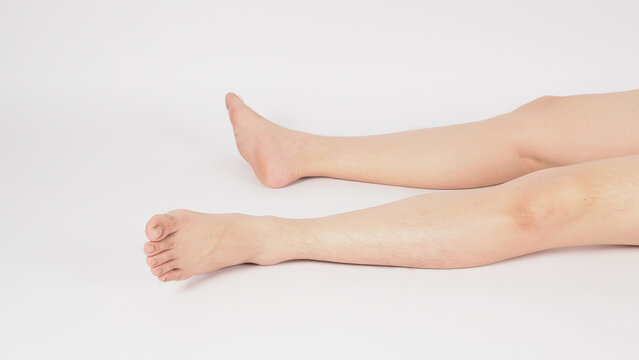 Asian Male legs and barefoot lie down on the white background.
