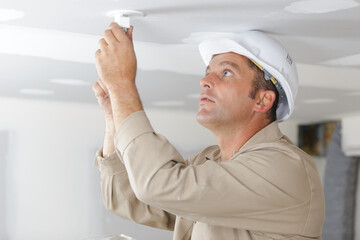man fitting a low energy cfl light bulb