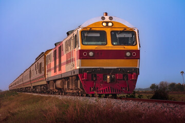 Obraz premium Passenger train by diesel locomotive on the railway.