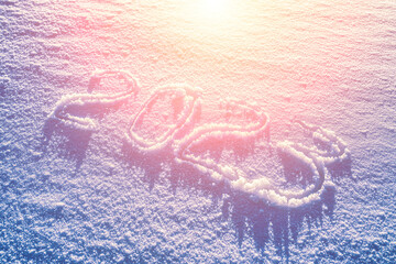 2023 written in the snow illuminated by sunlight. New year and christmas concept.